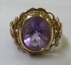 A 9ct gold fancy ring, set with a central amethyst and small diamond shoulders