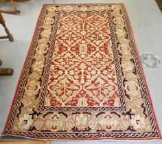 A Persian design rug with floral motifs, on a red and beige ground  60" x 82"