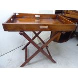 An early 20thC military design mahogany butler's tray with hinged ends, on a folding stand