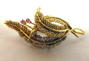 An 18ct gold brooch, fashioned as entwined leaves, set with two small pink stones