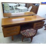 A G-Plan teak kneehole dressing table, surmounted by a horizontal mirror, over an arrangement of