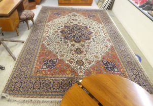 A Persian carpet, decorated with stylised floral designs, on a multi-coloured ground  96" x 128"