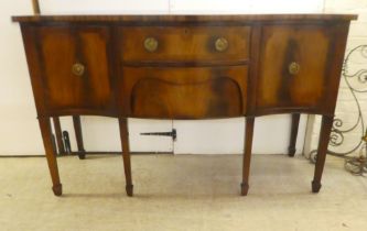 A reproduction of a Georgian style string inlaid, mahogany finished, serpentine front sideboard with