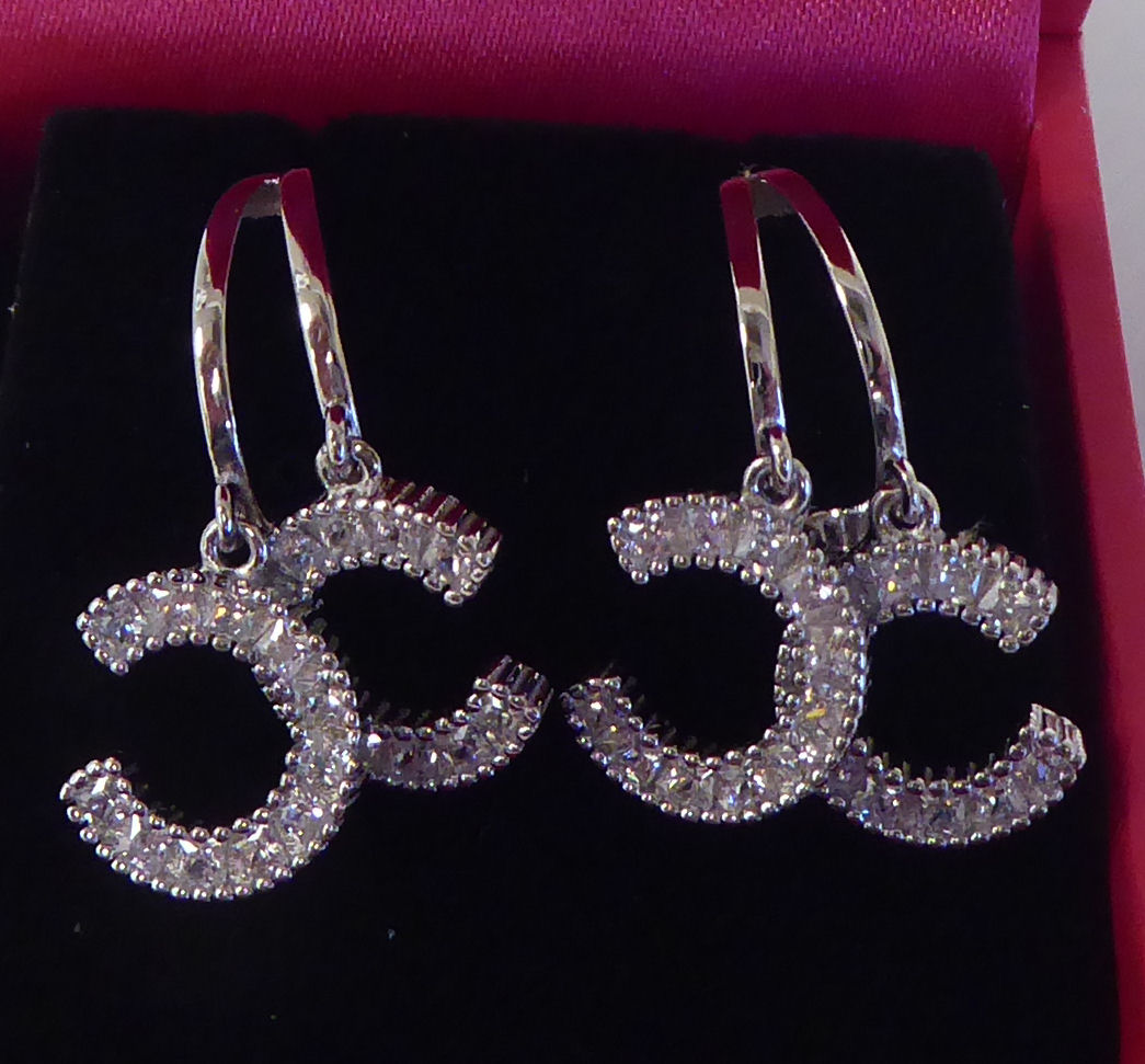 A pair of silver coloured metal designer earrings, set with cubic zirconia