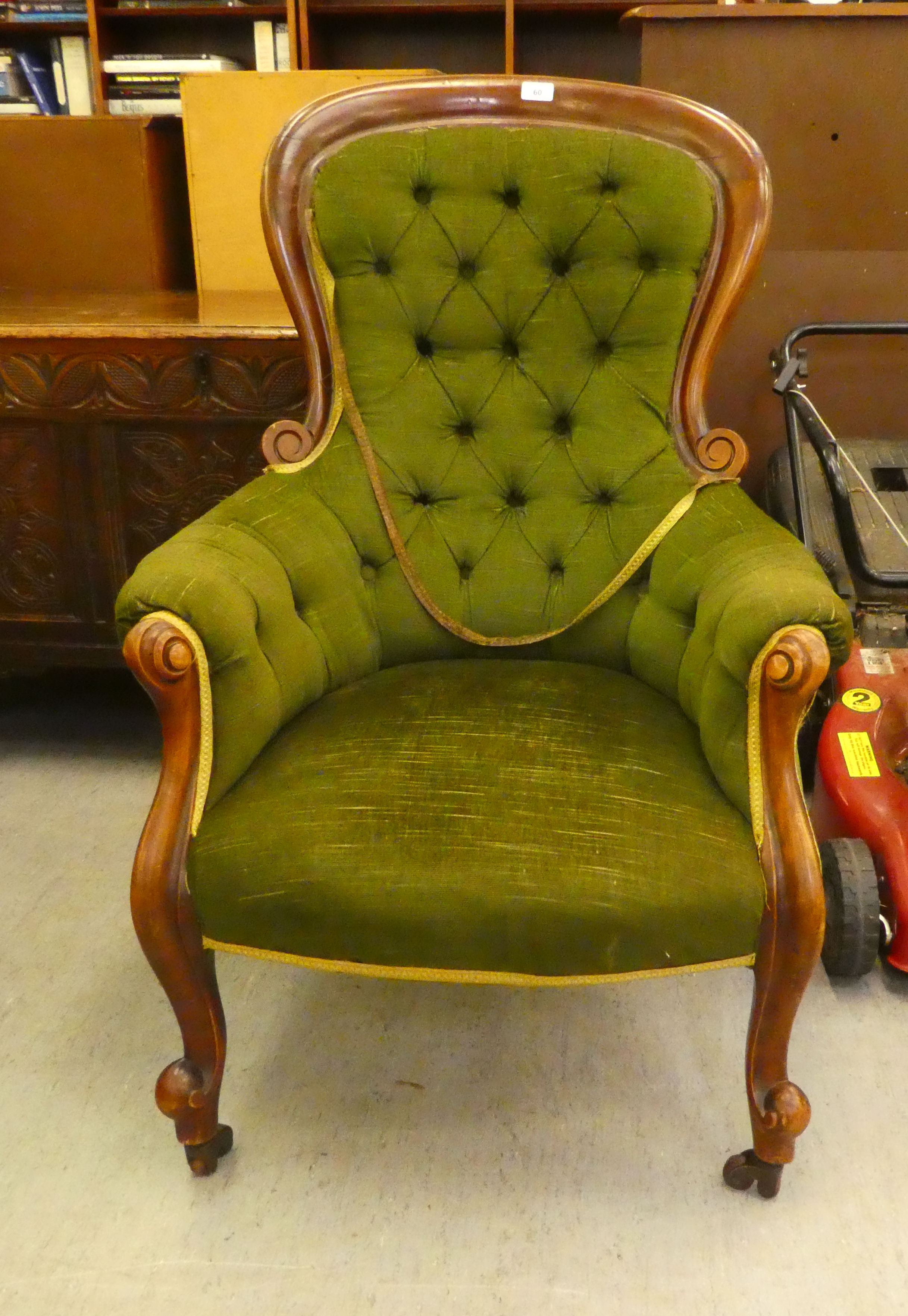 A late Victorian mahogany framed salon chair with a button upholstered spoonback, raised on cabriole