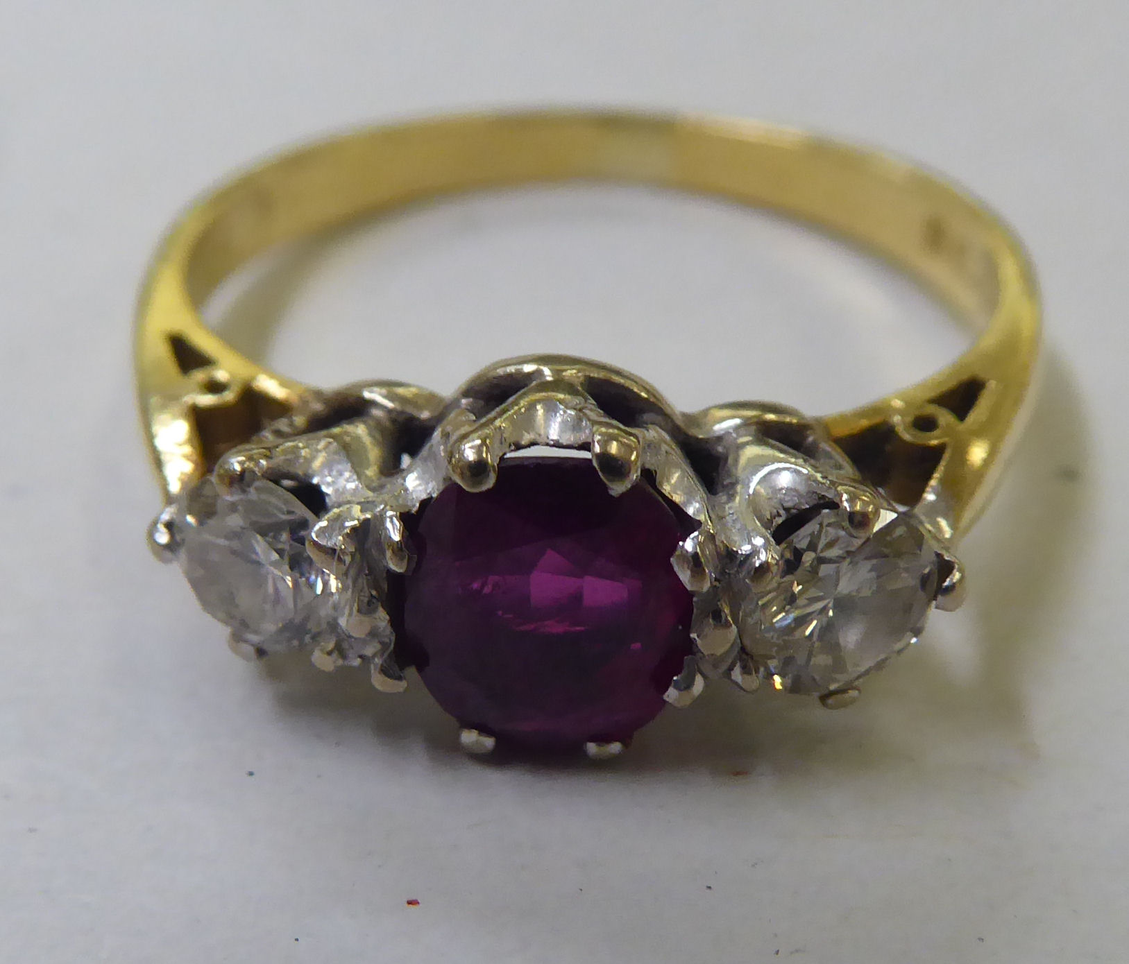 An 18ct gold ring, claw set with a central ruby, flanked by two diamonds