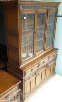 A Wood Bros Lancaster oak display cabinet, the three glazed doors, over a bank of three drawers