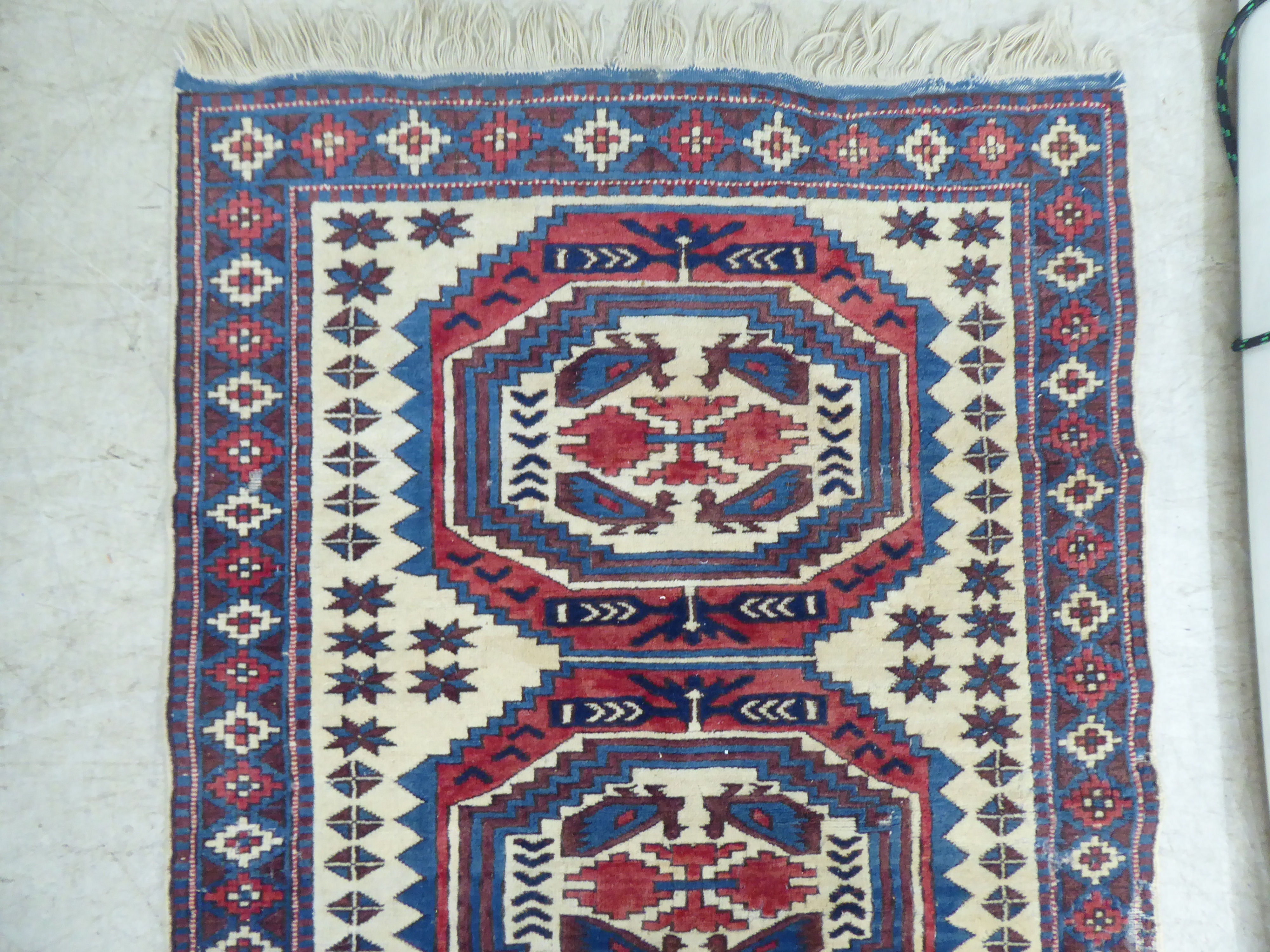 A North African rug, decorated with three octagonal motifs, bordered by repeating designs, on a - Image 2 of 5