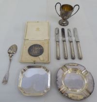 Silver items: to include a miniature, twin handled pedestal trophy cup; and a square coaster