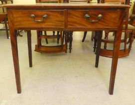 A late 19thC mahogany writing table with two inline deep drawers and brass bail handles, raised on