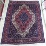 A Persian rug, decorated with a central diamond shaped motif, bordered by repeating designs, on a