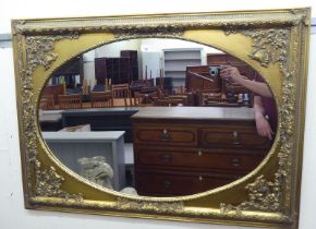 A 20thC mirror, the oval plate set in an antique inspired, moulded gilt frame  30" x 42"