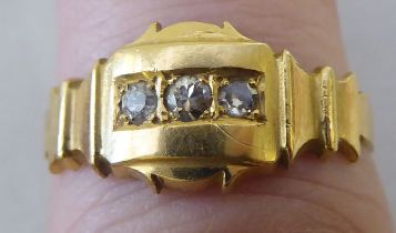 A yellow metal ring, set with three diamonds