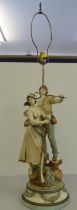 A French ceramic and painted metal figural table lamp, featuring two young artisan figures  bears