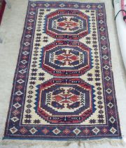 A North African rug, decorated with three octagonal motifs, bordered by repeating designs, on a