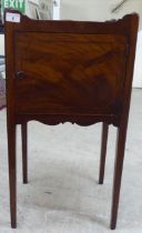 A George III mahogany night commode with a shallow gallery top, over a cupboard door, raised on