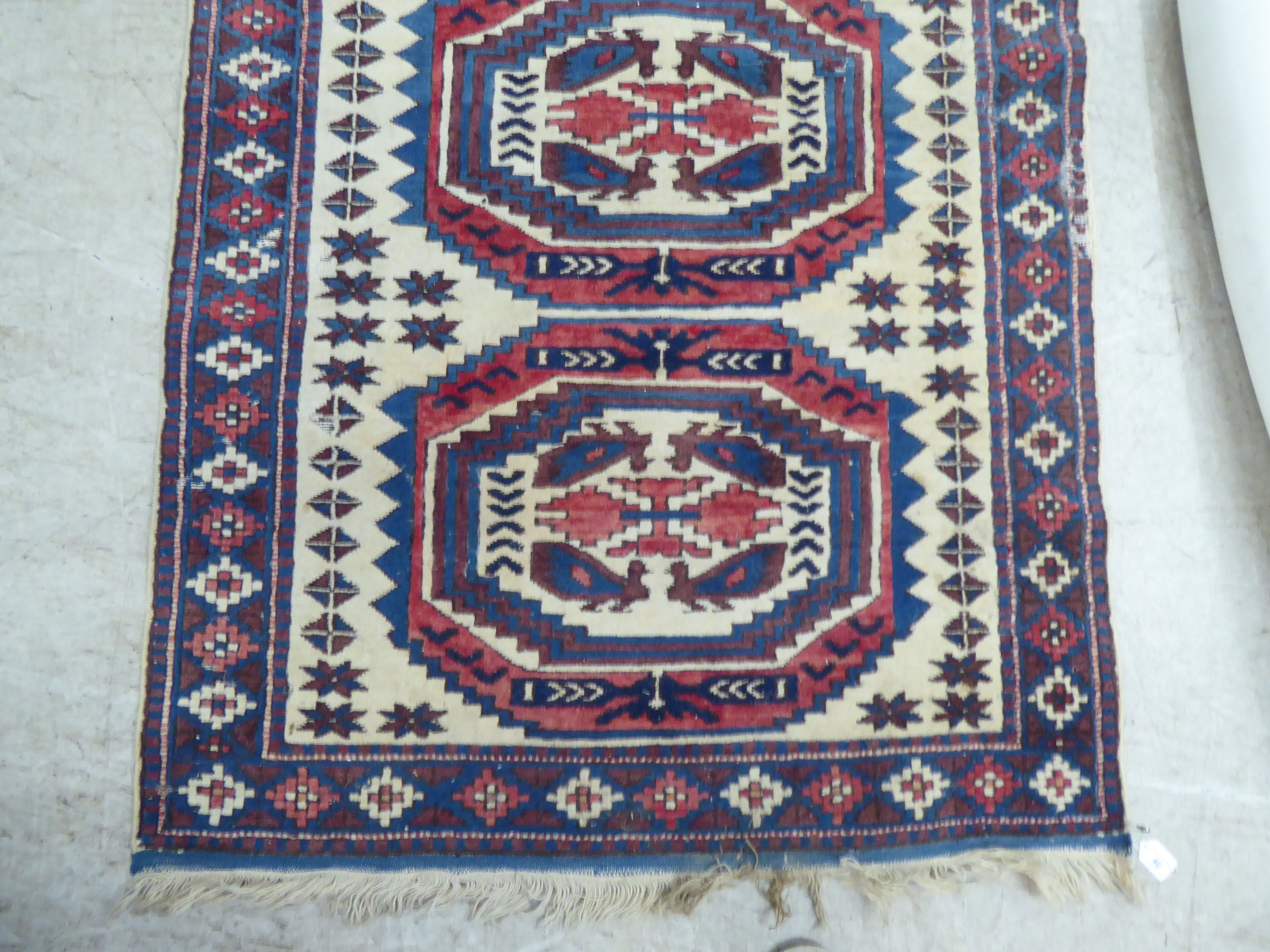 A North African rug, decorated with three octagonal motifs, bordered by repeating designs, on a - Image 3 of 5