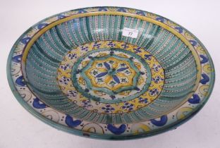 A Moroccan pottery bowl, decorated with a central eight point star and other geometric patterns