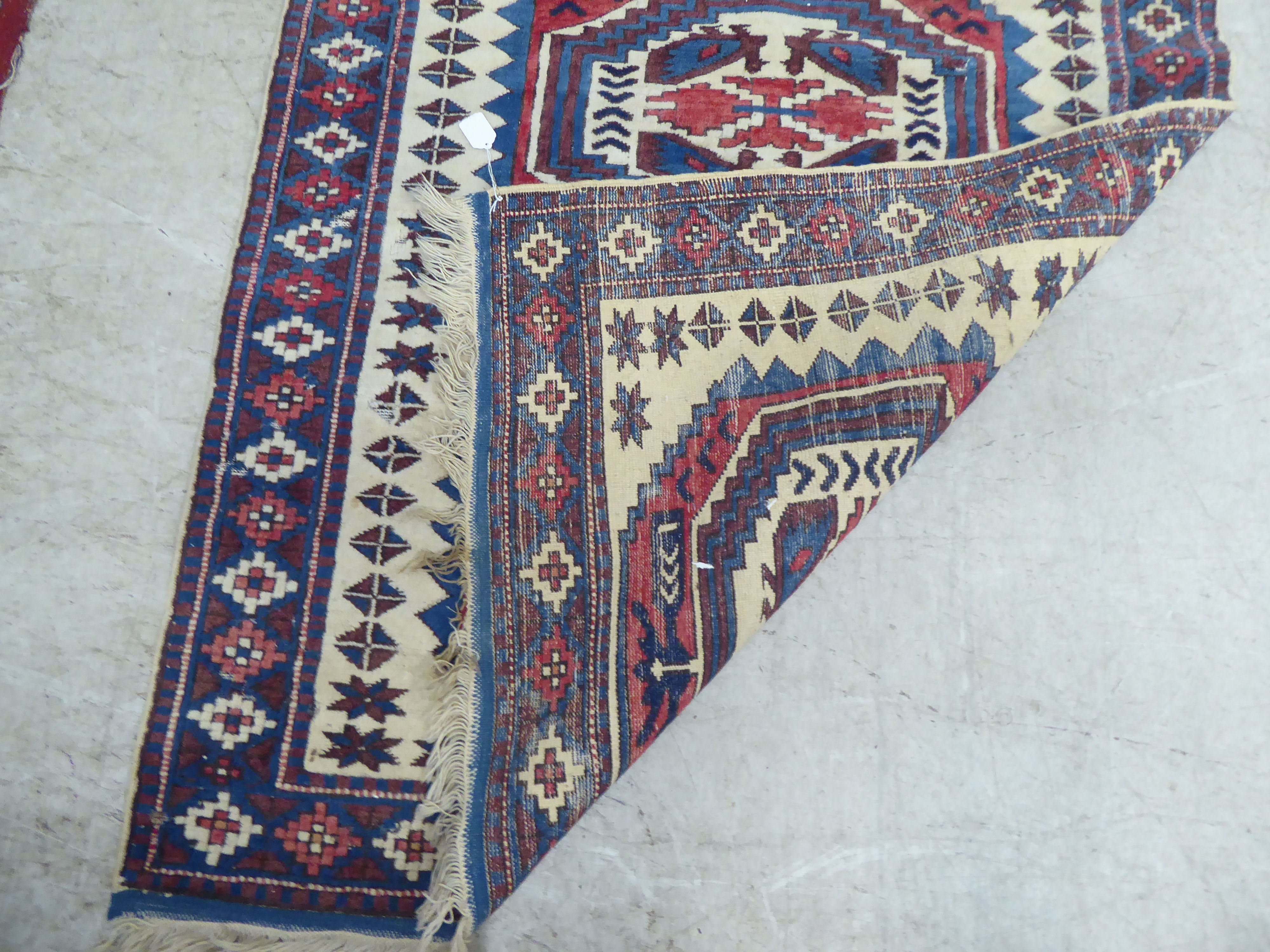A North African rug, decorated with three octagonal motifs, bordered by repeating designs, on a - Image 4 of 5