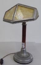 An Art Deco alloy and wooden desklamp with an angled shade, on a straight stem and loaded base