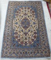 A Persian part silk woven rug, decorated with floral designs, on a cream coloured, pale blue and