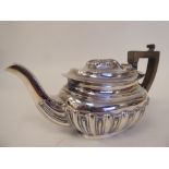 An early 20thC silver bachelors teapot of oval, demi-reeded and stop-fluted form with a swept spout,
