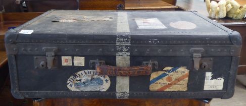 An early 20thC moulded/press composition travelling trunk with a hinged lid, bearing various