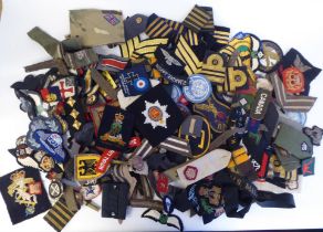 A miscellaneous collection of military and related embroidered and printed uniform badges and