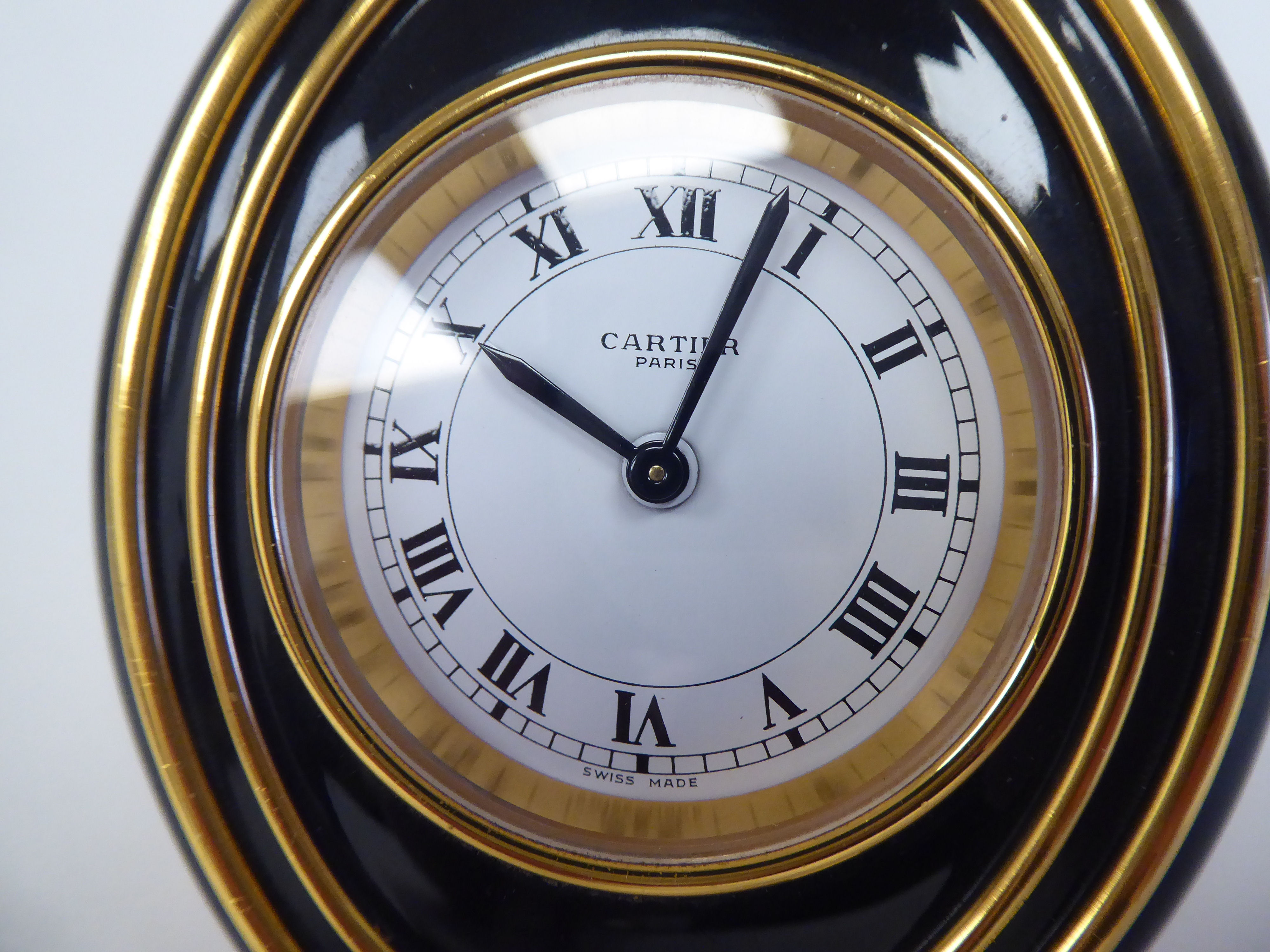 A Cartier travel clock, No.7511 00638, in a gilded and black enamel oval case, on an easel stand; - Image 4 of 6