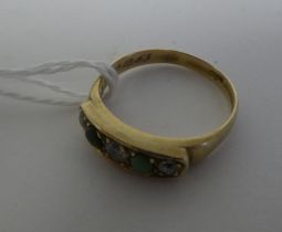An 18ct gold, rubover set diamond and green stone ring
