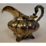 A George IV silver melon shape cream jug with a flared rim on S-scrolled handle, on a shell cast