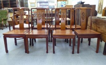 A set of seven modern Chinese, rosewood framed dining chairs, each with a dragon carved splat,