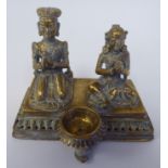 A pair of Asian brass religious deities, seated on a plinth between an outset pedestal vase  5"h