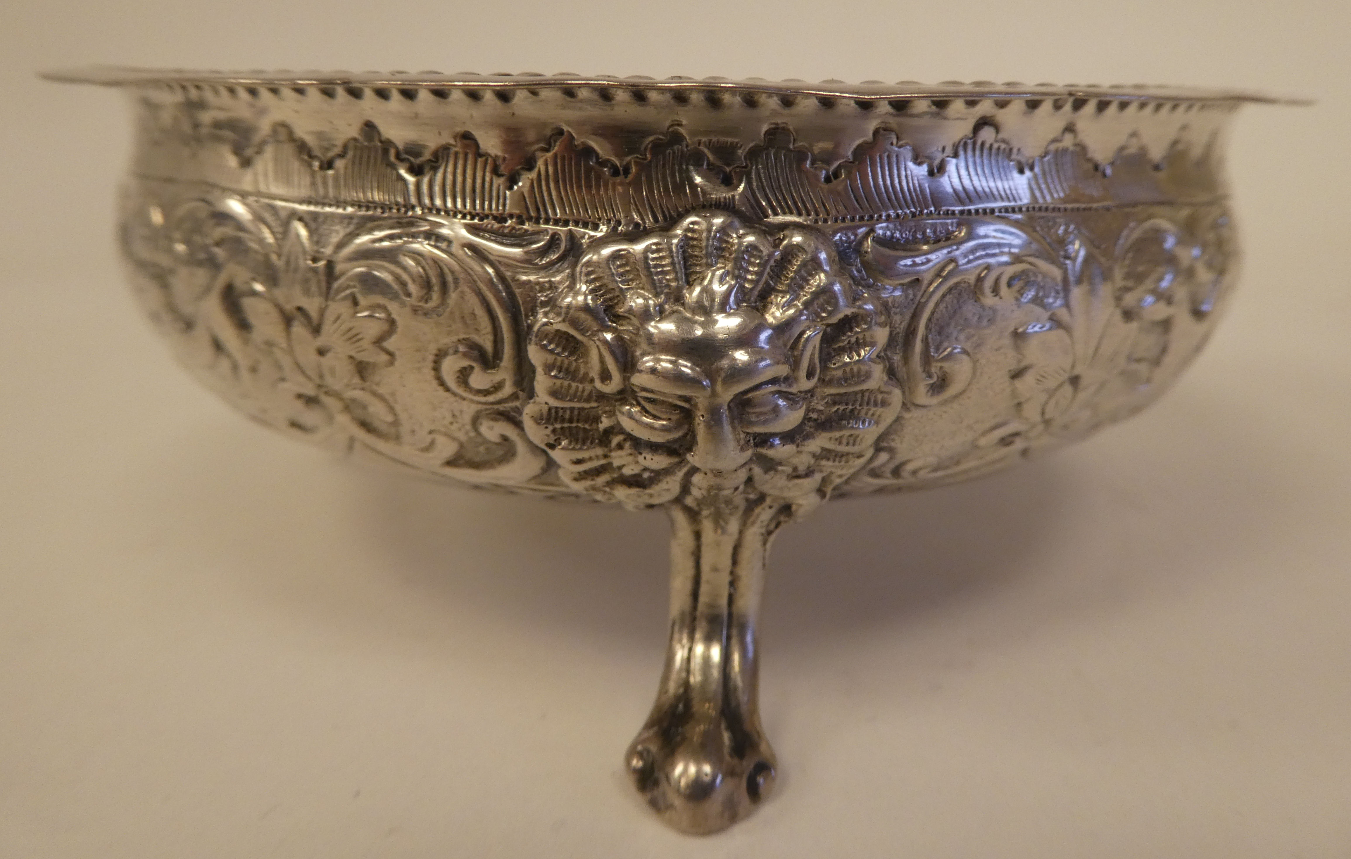 A late Victorian silver shallow bowl with a crimped rim, embossed foliage, flora and lion mask - Image 2 of 4