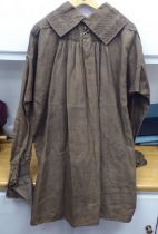 A Continental artisan's brown calico pleated smock with simple decoration to the colour