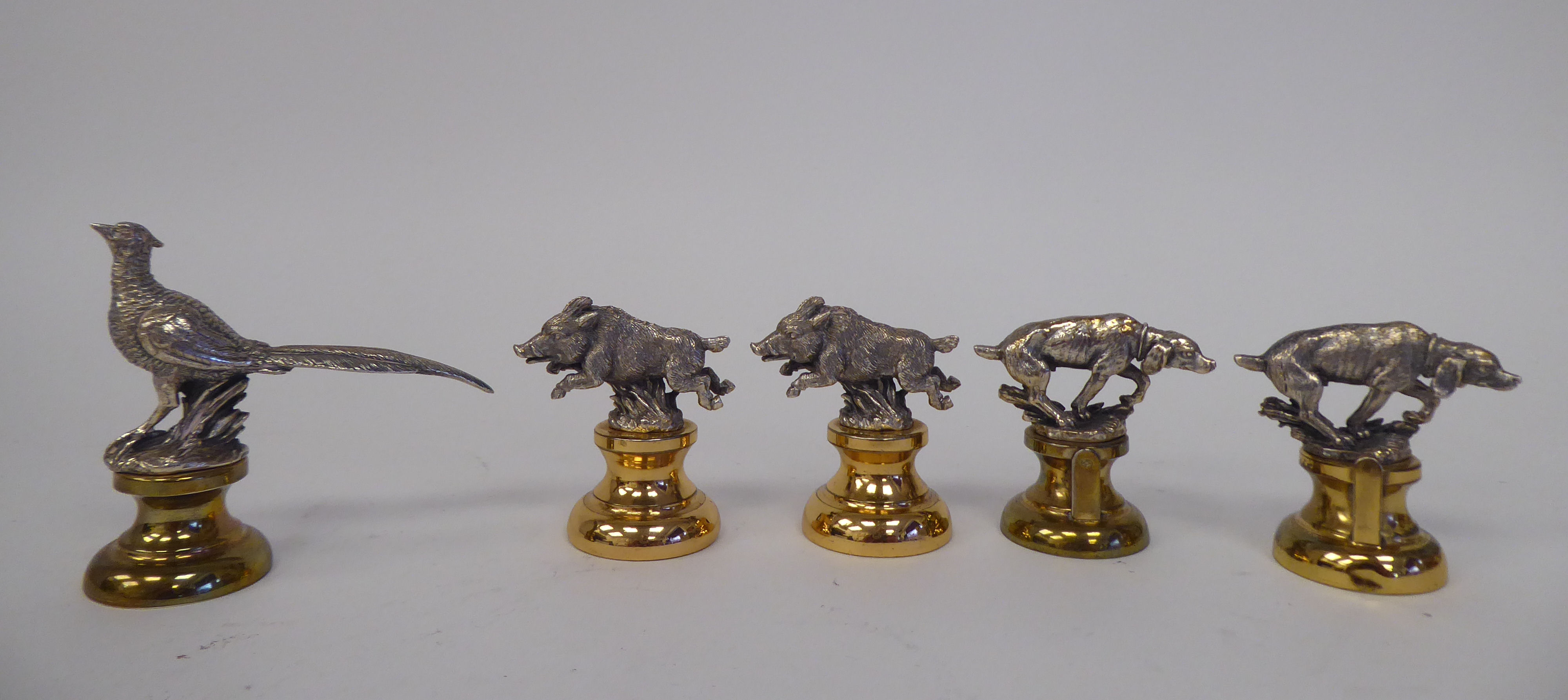 A set of five Holland & Holland silver and gilt coloured metal novelty menu holders, featuring