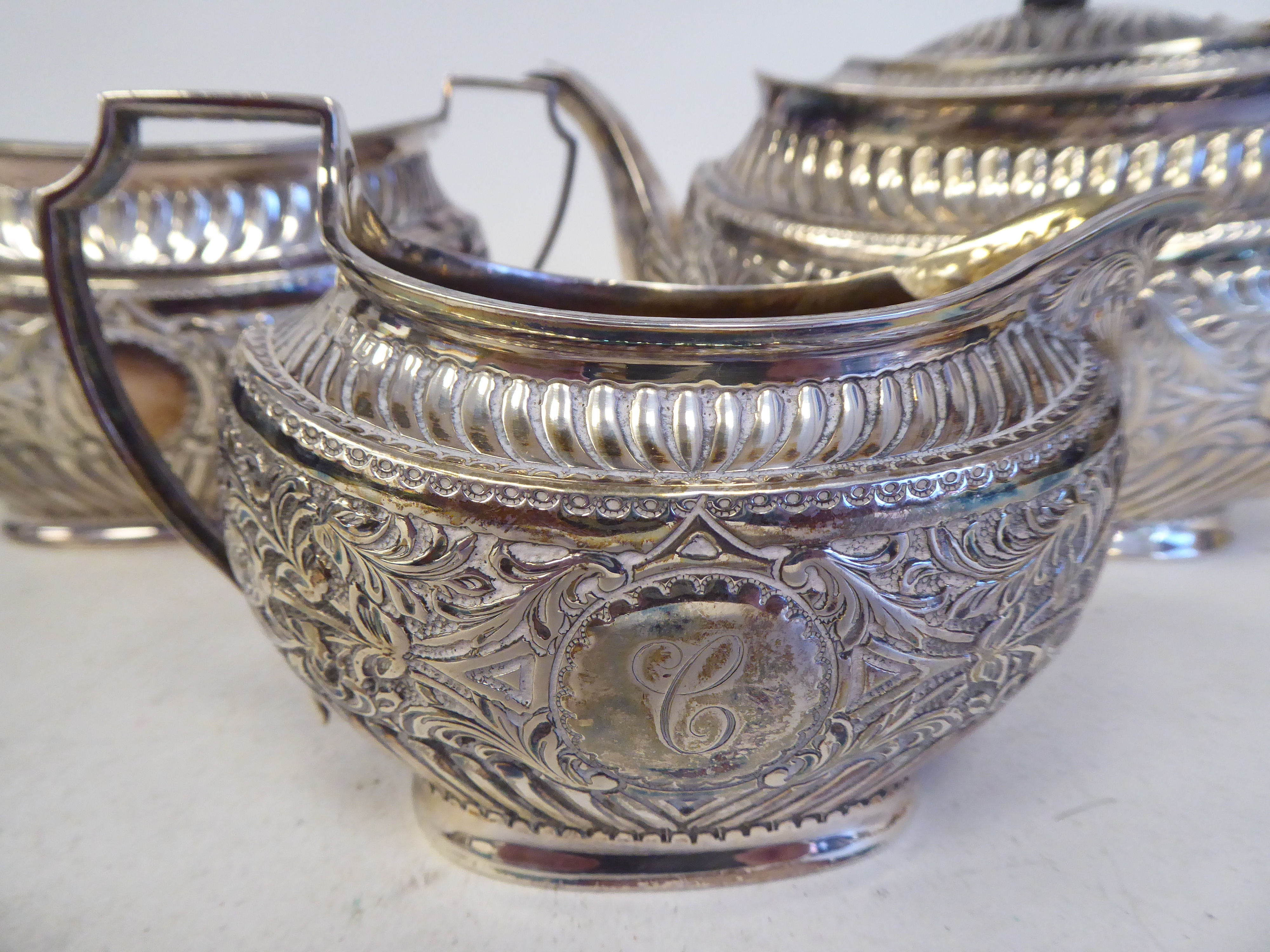 A late Victorian silver three piece tea set of oval form with engraved, chased and demi-reeded - Image 3 of 10