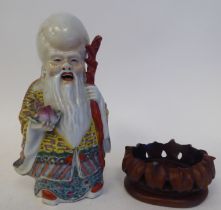 An early 20thC Chinese porcelain figure, a robed, standing scholar, decorated in famille rose and