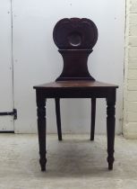 A William IV mahogany hall chair with a twin C-scroll design back, the solid seat raised on ring