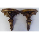 A pair of late 19thC carved wooden and gilt gesso moulded wall brackets, each featuring a semi-