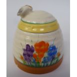 A Clarice Cliff Bizarre, Newport Pottery, Crocus pattern honeypot, the lid surmounted by a bee