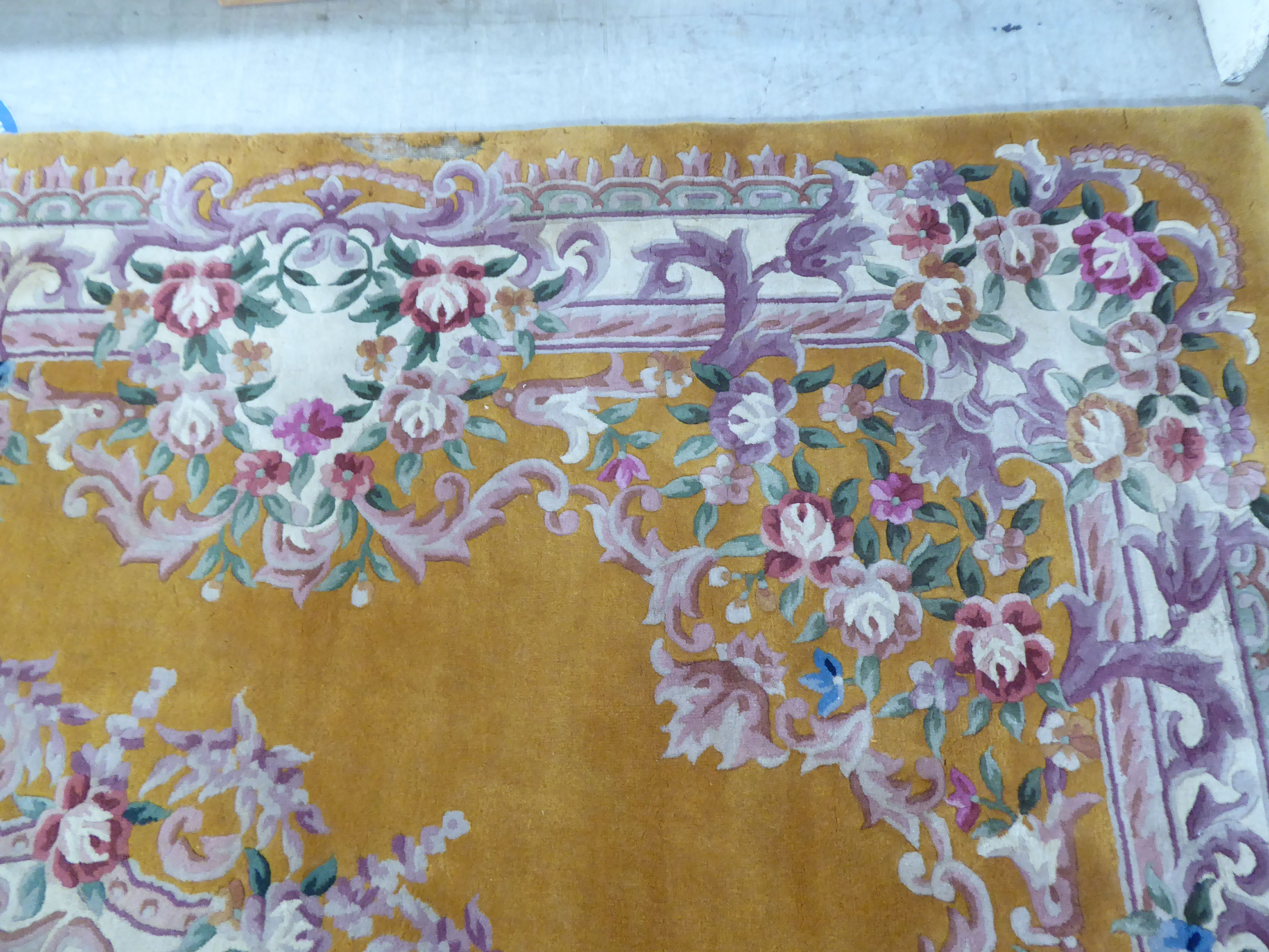 A traditional 20thC Chinese washed woollen carpet, decorated with flora, on a mustard coloured - Image 3 of 6