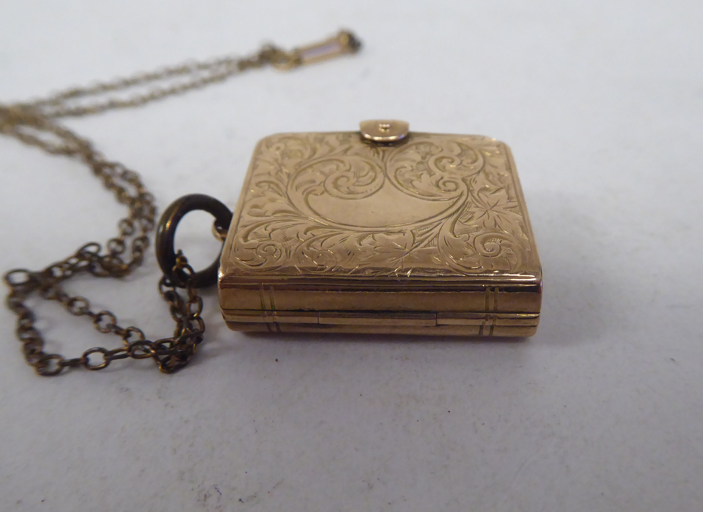 A late Victorian foliate scrolled yellow metal locket, fashioned as a book, on a clasp, revealing - Image 5 of 7