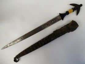 A North African dagger with a carved and black painted handgrip, the blade with engraved ornament
