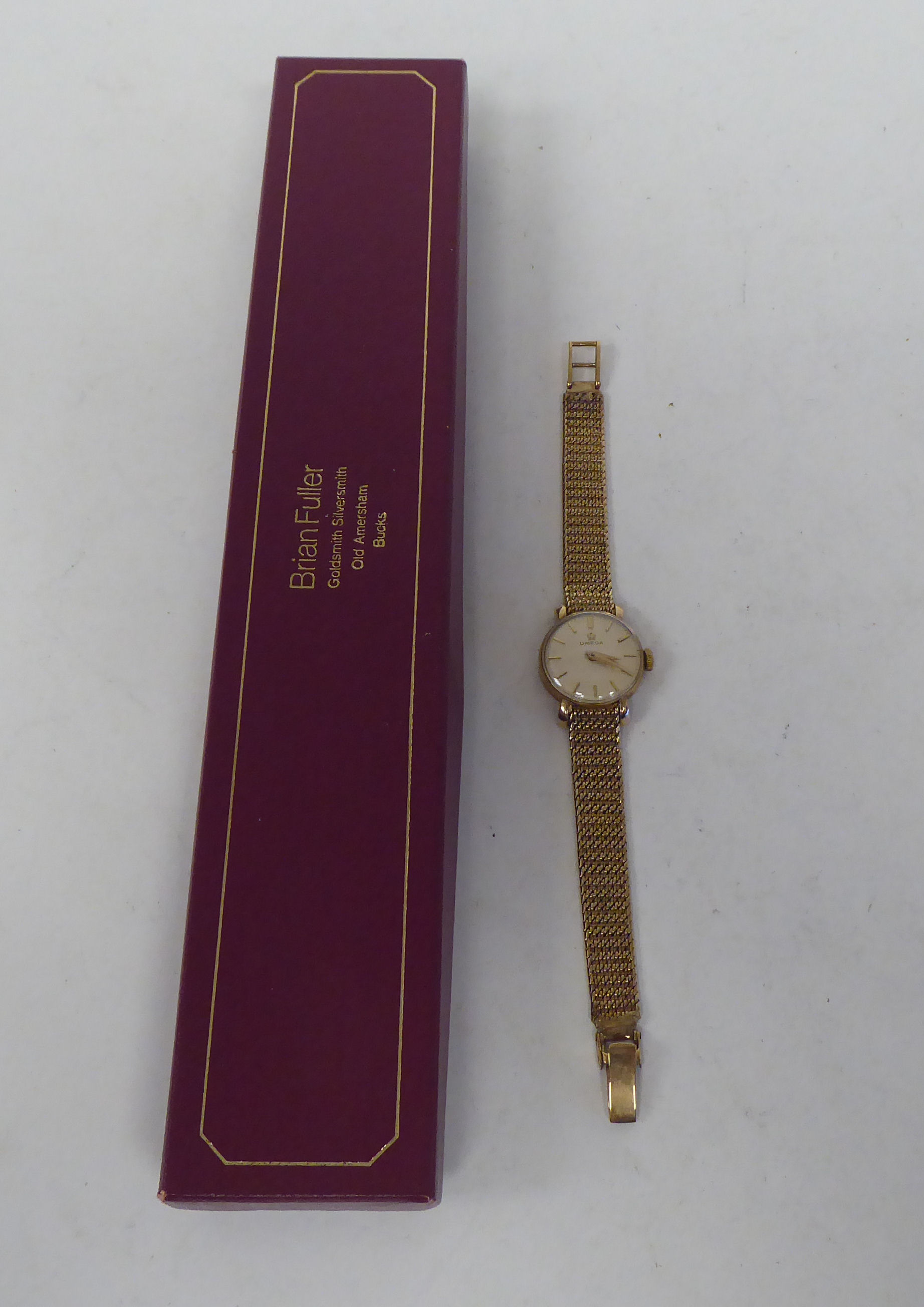 A lady's Omega 9ct round cased bracelet wristwatch, the manual wind mechanism faced by a baton dial