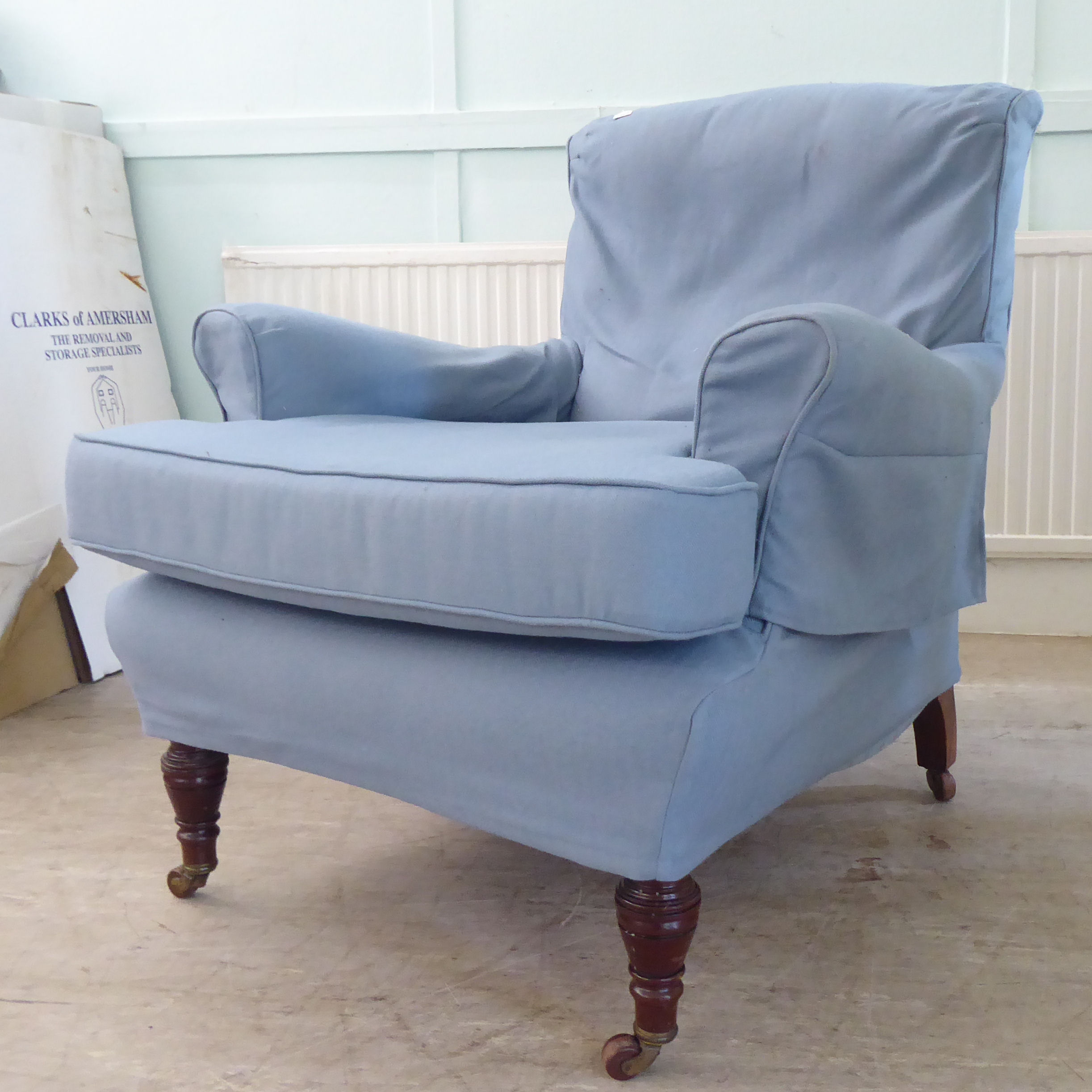A late Victorian library chair with a level back and enclosed arms, re-upholstered in patterned blue