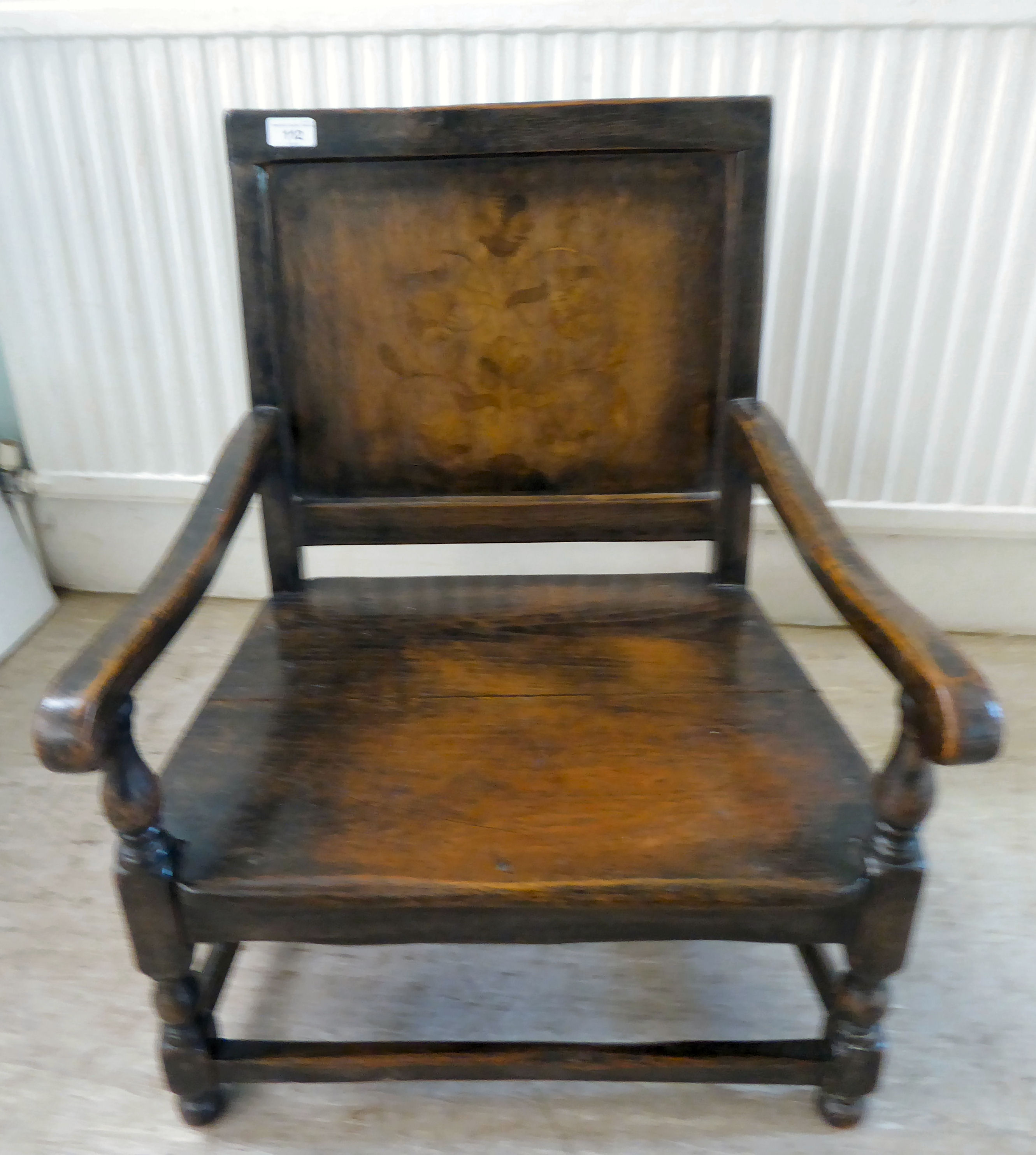 An antique finished, dark stained oak floral marquetry, panelled back, low, open arm chair with a - Image 2 of 5