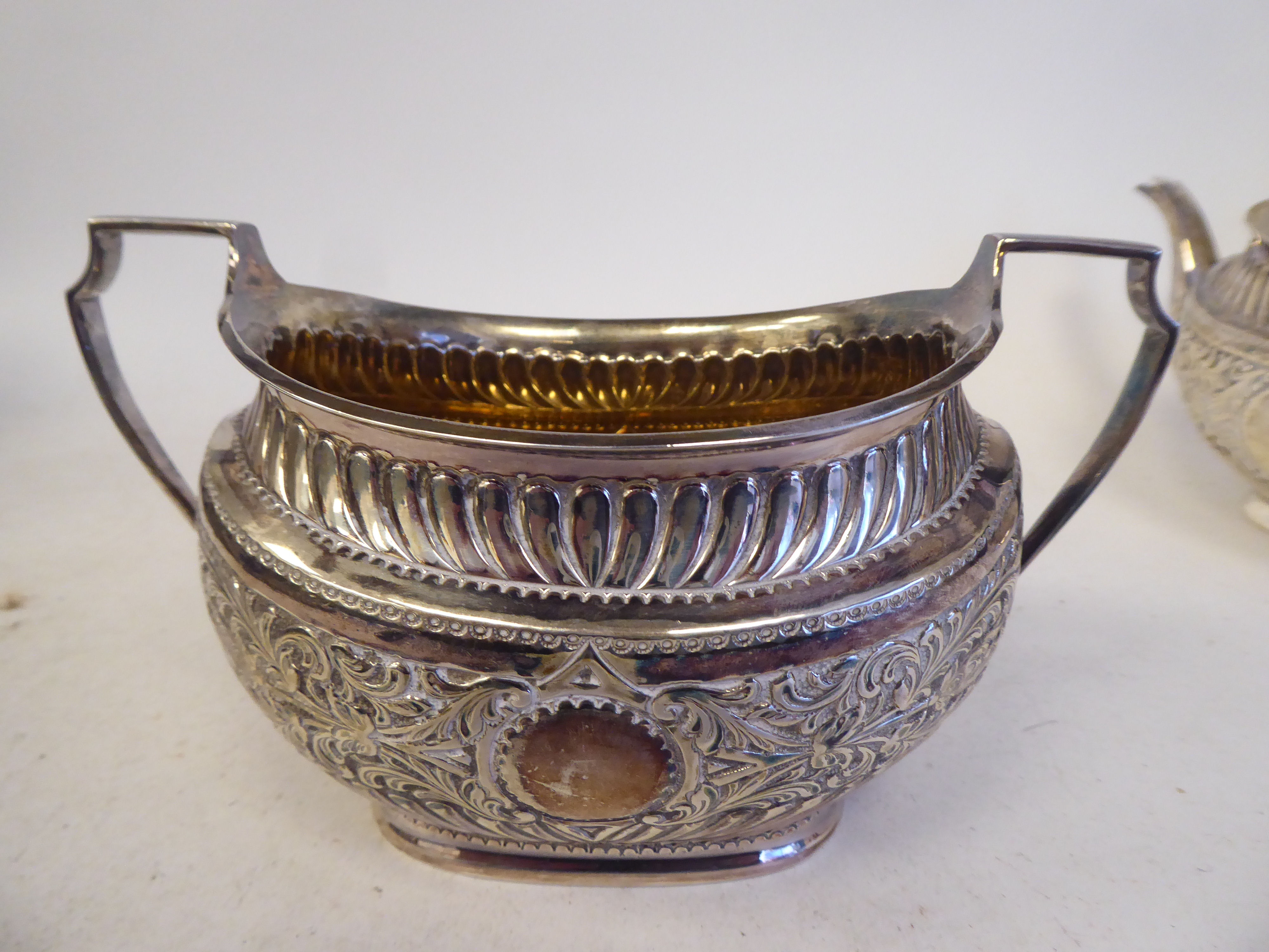 A late Victorian silver three piece tea set of oval form with engraved, chased and demi-reeded - Image 6 of 10