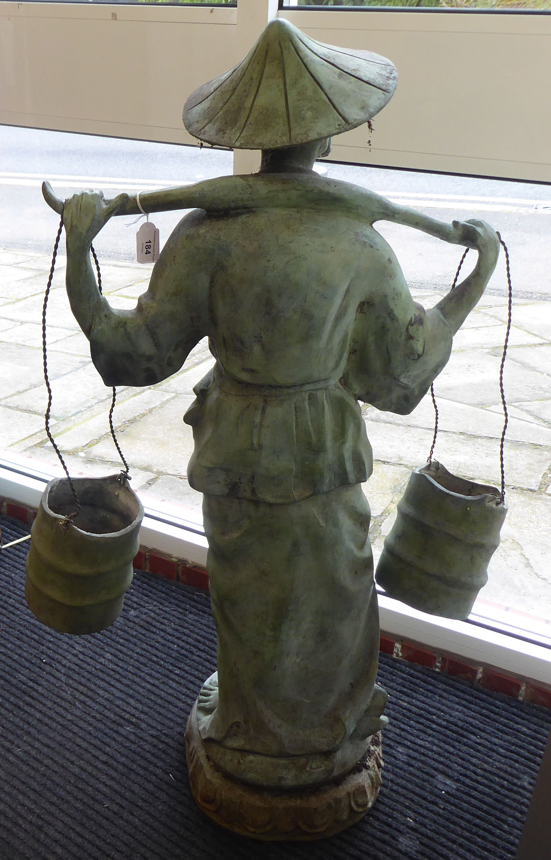 A 20thC cast and patinated green bronze standing Asian artisan figure, a bearded man, carrying two - Image 4 of 4