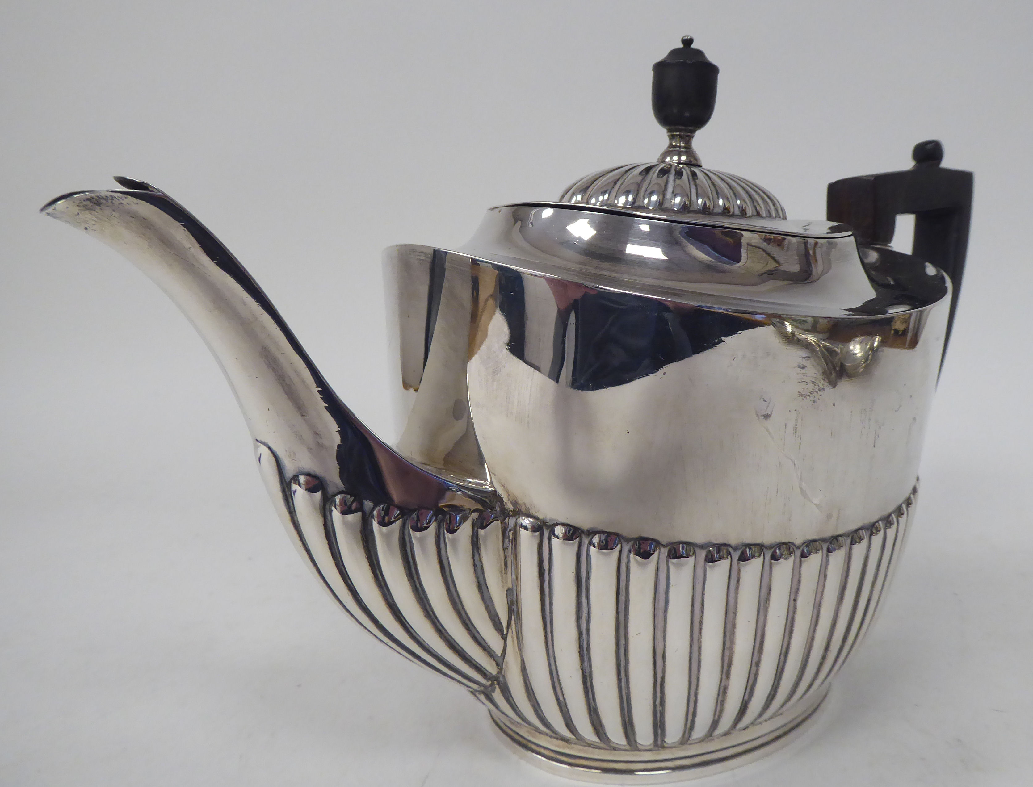 A late Victorian silver teapot of oval, demi-reeded form with a swept spout, hinged lid, ebonised - Image 2 of 4